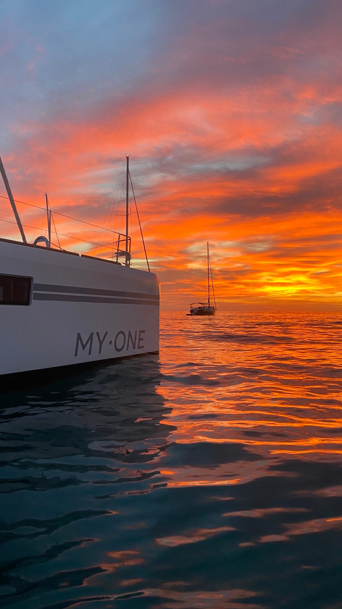 Rumpf der MY·ONE mit Schriftzug im Abendrot, Spiegelung im Wasser